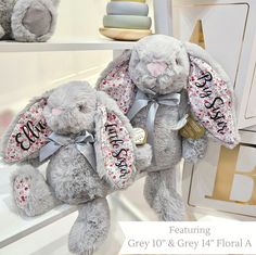 two gray stuffed animals sitting on top of shelves