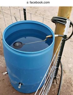 a large blue barrel sitting next to a yellow pole