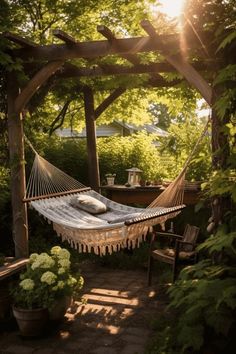 a hammock in the middle of a garden with sun shining through trees and bushes