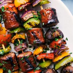 skewered meat and vegetables on a white plate