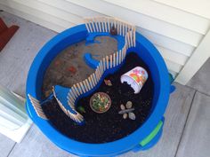 a blue plastic container filled with dirt and rocks