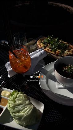 a table topped with plates and bowls filled with food next to glasses of liquid on top of them