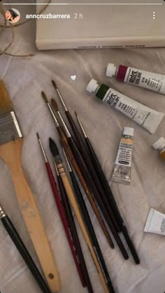 an assortment of paint and brushes on a table