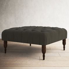 the footstool is made out of wood and has an upholstered design