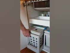 a man is opening the bottom shelf of a microwave oven and it's door open