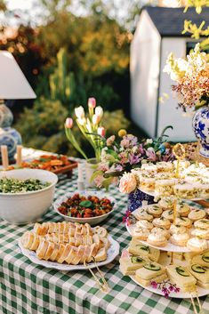 a table topped with lots of food next to a green and white checkered table cloth