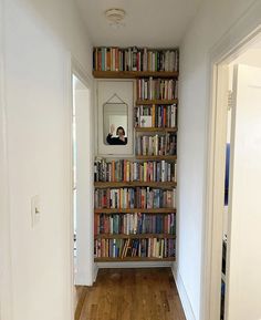 there is a bookshelf full of books in the hallway