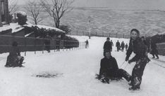 some people on skis in the snow and one is sitting down with another person standing up