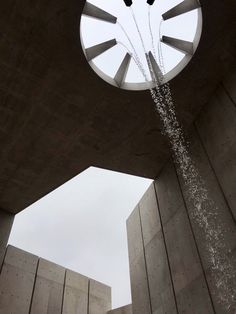 a clock tower with water spewing out of it's sides in the air