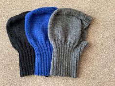 three pairs of knitted mittens laying on the floor