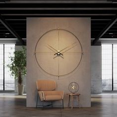 a large clock mounted to the side of a wall next to a chair and table