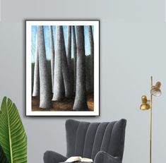 a living room with a chair, table and painting on the wall in front of it