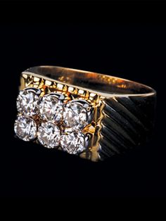 a gold ring with three diamonds on it's sides and two rows of stones in the middle