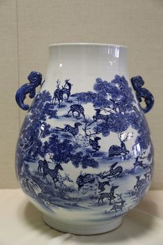 a blue and white vase sitting on top of a table