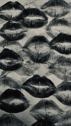 black and white photograph of many lips on the ground with grass growing out of them