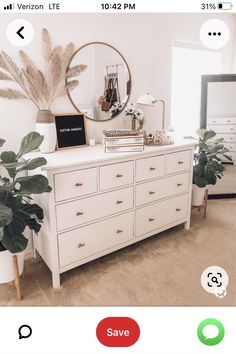 a white dresser and mirror in a room with plants on the top shelf, potted plant next to it