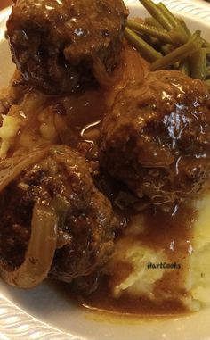 meatballs, mashed potatoes and gravy on a plate with green beans