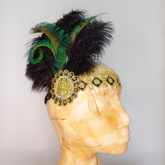 A beautiful Flapper-style headband with a black and gold band that sits across the forehead, large beaded embellishment, soft black ostrich feathers and curled green feathers. At the back, the band has a section of black sequinned elastic, allowing it to fit most head sizes and making it comfortable to wear. Perfect for adding that finishing touch to your party outfit or performance costume. The width of the band is approximately 2.5cm/1 inch. This piece has been designed and made by the lovely Green Feathers, Style Headband, Performance Costume, Flapper Style, Gold And Green, Turban Headbands, Ostrich Feathers, Turbans, Hair Accessories Headbands