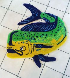 a fish rug is on the floor next to a tiled floor with tiles in it