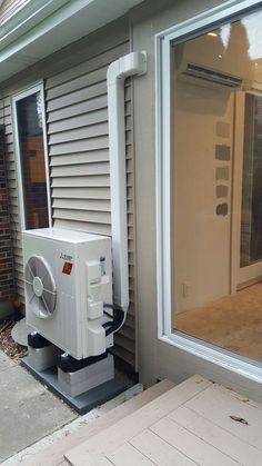 an air conditioner sitting on the side of a house