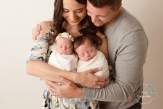 a man and woman holding a baby in their arms