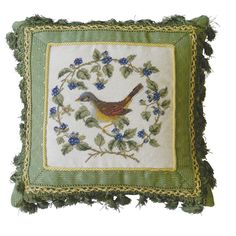 a green pillow with a bird on it's side and blue flowers around the edges