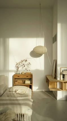 a bedroom with a bed, dresser and lamp hanging from it's side wall