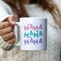 a woman holding a coffee mug with the words mama mamma on it's side