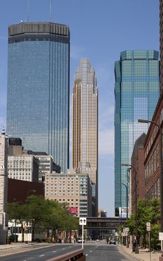 an empty city street with tall buildings in the background