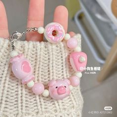 a hand holding a pink and white bag with donuts on it