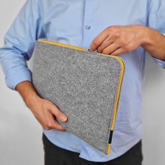 a man holding a gray and yellow case