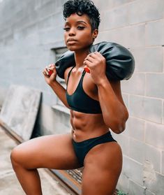 a woman posing for the camera while wearing a black sports bra top and matching shorts