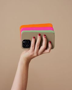 a woman's hand holding up an iphone case with multiple colors on the cover