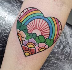 a heart shaped tattoo with flowers and rainbows