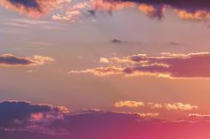 an airplane flying in the sky at sunset with clouds and sunbeams behind it