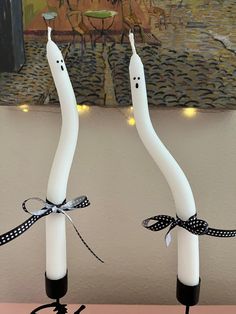 two white candles with black bows on them