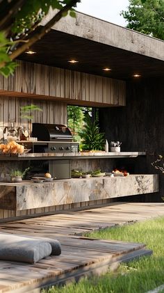 an outdoor kitchen and dining area is shown in this image, with green grass on the ground