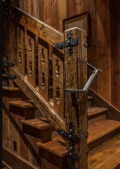 an old wooden staircase with iron handrails and wood paneling on the walls