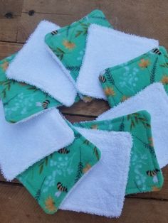 several pieces of green and white towels on a wooden surface