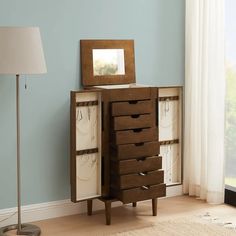 a wooden dresser with drawers and a mirror on it's top shelf next to a lamp