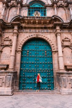 a woman standing in front of a large blue door