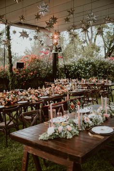 an outdoor wedding reception setup with wooden tables and star decorations