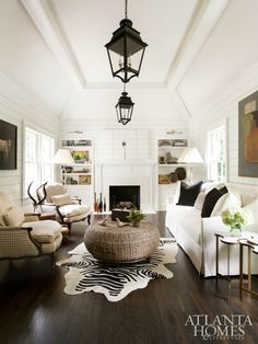 a living room filled with furniture and a fire place in front of a white fireplace