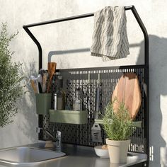 a potted plant sitting on top of a metal shelf next to a cutting board