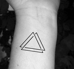 a small triangle tattoo on the wrist