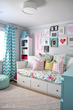 a living room filled with furniture and pictures on the wall next to a window covered in curtains