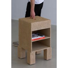 a man standing next to a small table made out of cinder blocks with a book on it