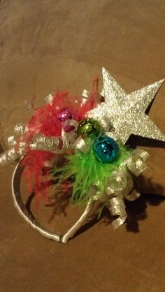 a star headband with colorful flowers and feathers on it sitting on a brown surface