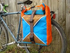 a bicycle parked next to a fence with a bag on it's handlebars