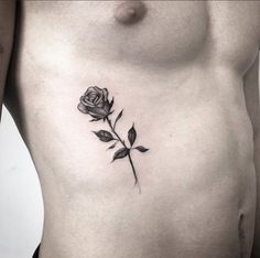 a rose tattoo on the chest is shown in black and grey ink, with leaves